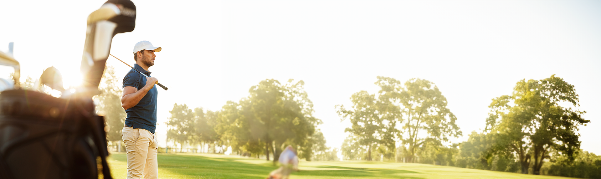 Male golfer holding driver while standing