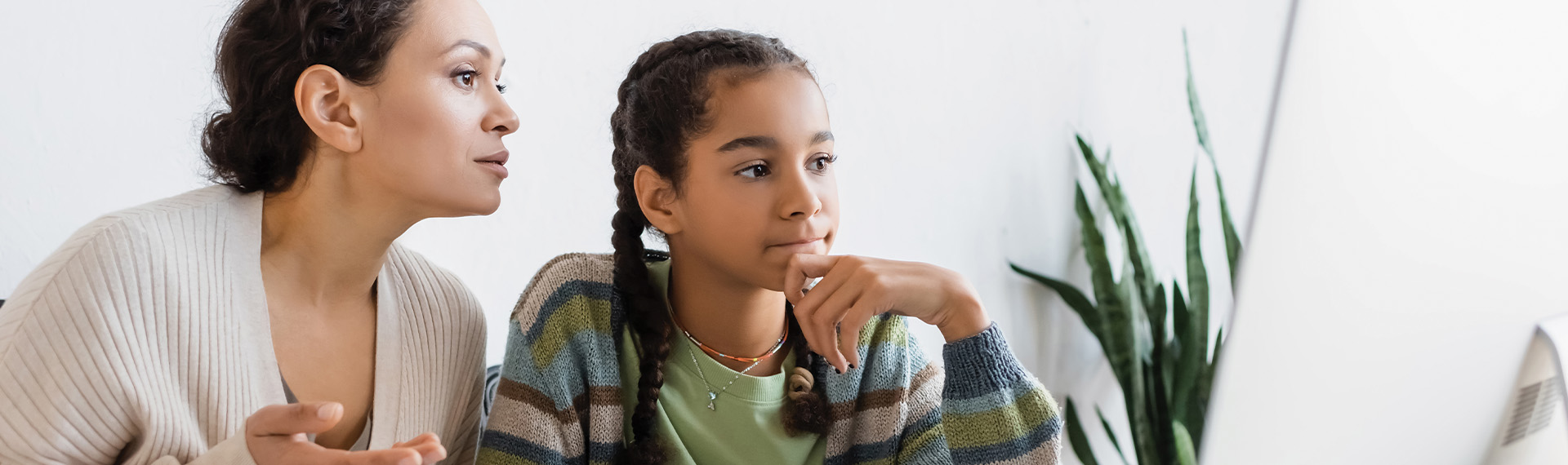 africa american woman pointing at computer monitor near thoughtful daughter banner